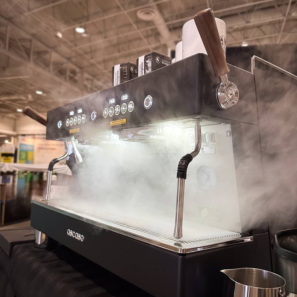 Máquina Ascaso Bar en acción, mostrando vapor mientras prepara un espresso