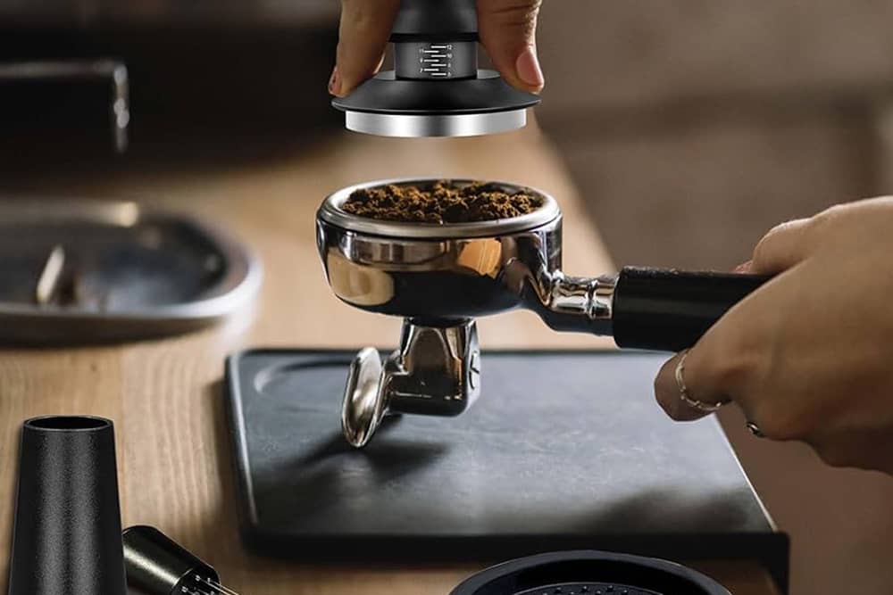 Vista de herramientas de barista, incluyendo tamper, distribuidor y jarras de leche