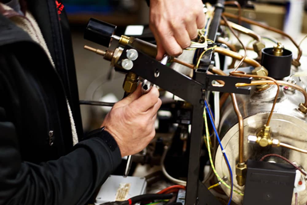 Técnico realizando mantenimiento en una máquina de café comercial