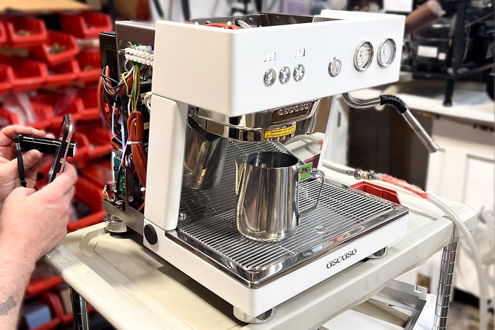 Técnico reparando una máquina de café comercial